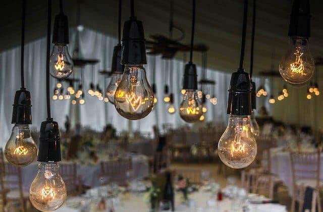 Mehrere Glühlampen hängen an einem Kabel in einer Hochzeitslocation.